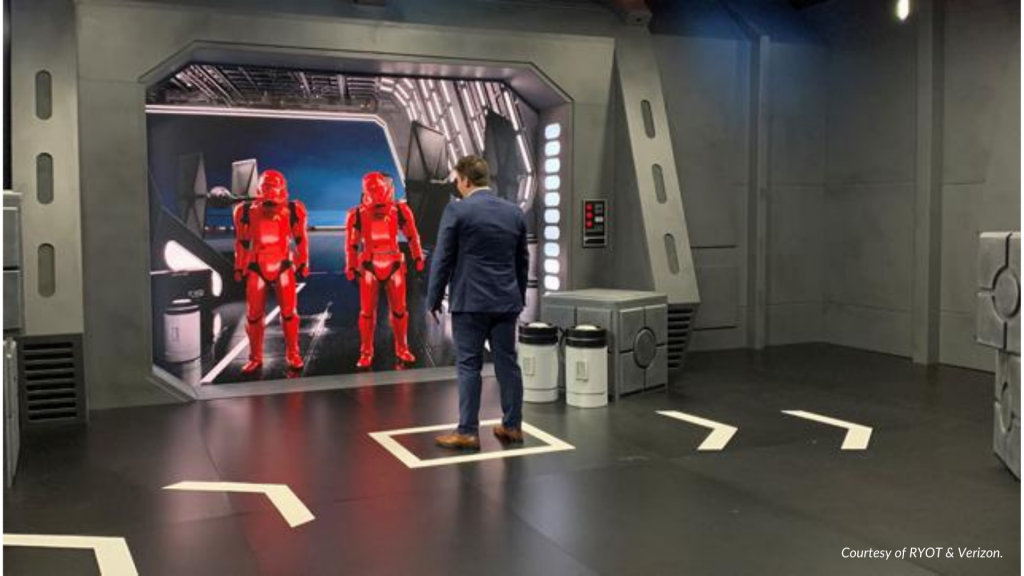A person stands in front of two virtual red Sith Jet Troopers.
