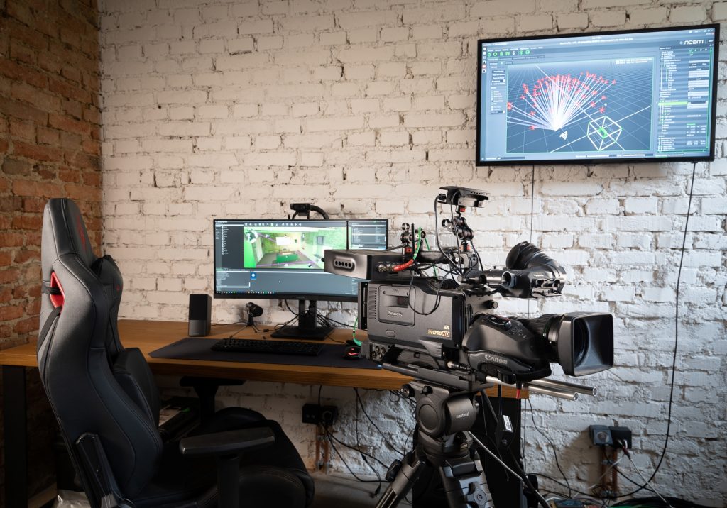 A camera rig sits next to a computer, which shows tracking points on screen.