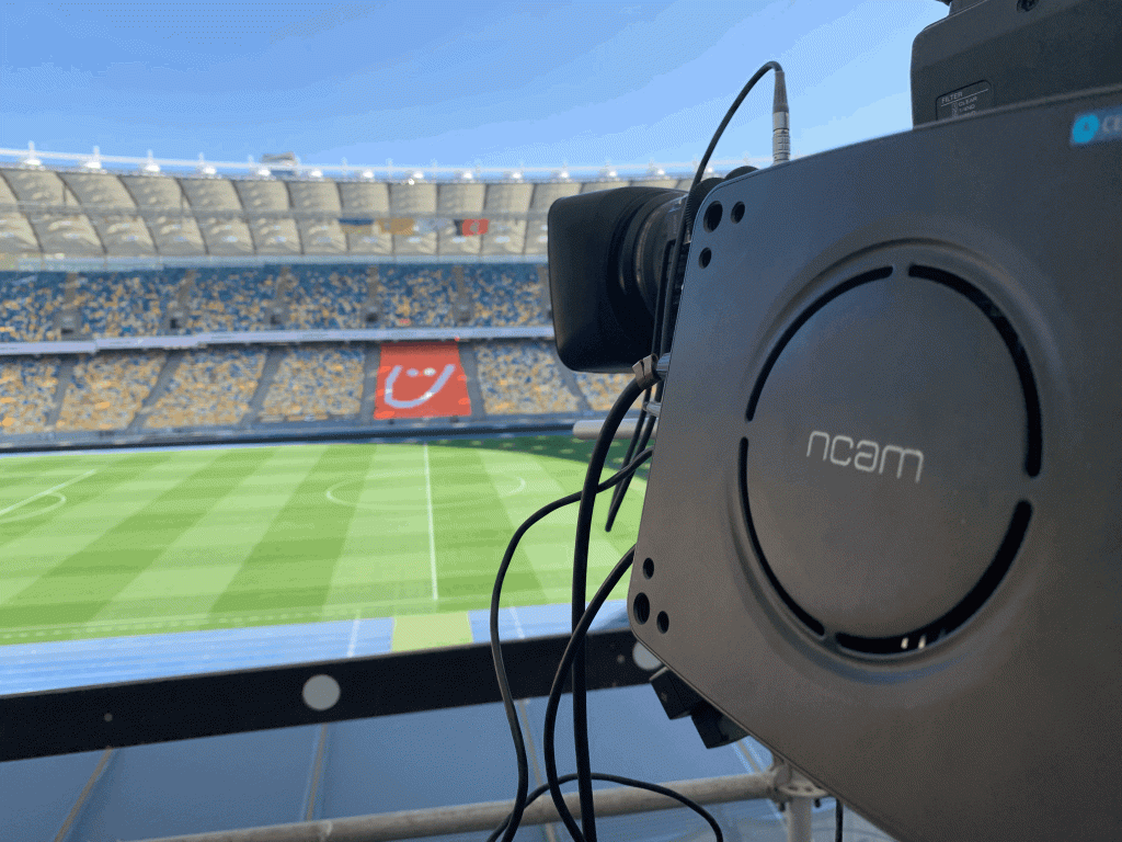 A camera equipped with Ncam tech points toward a large stadium.